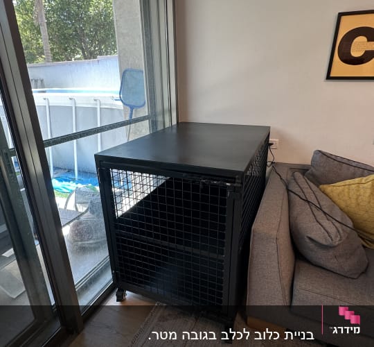 כלוב מתכת שחור ליד חלון וספה